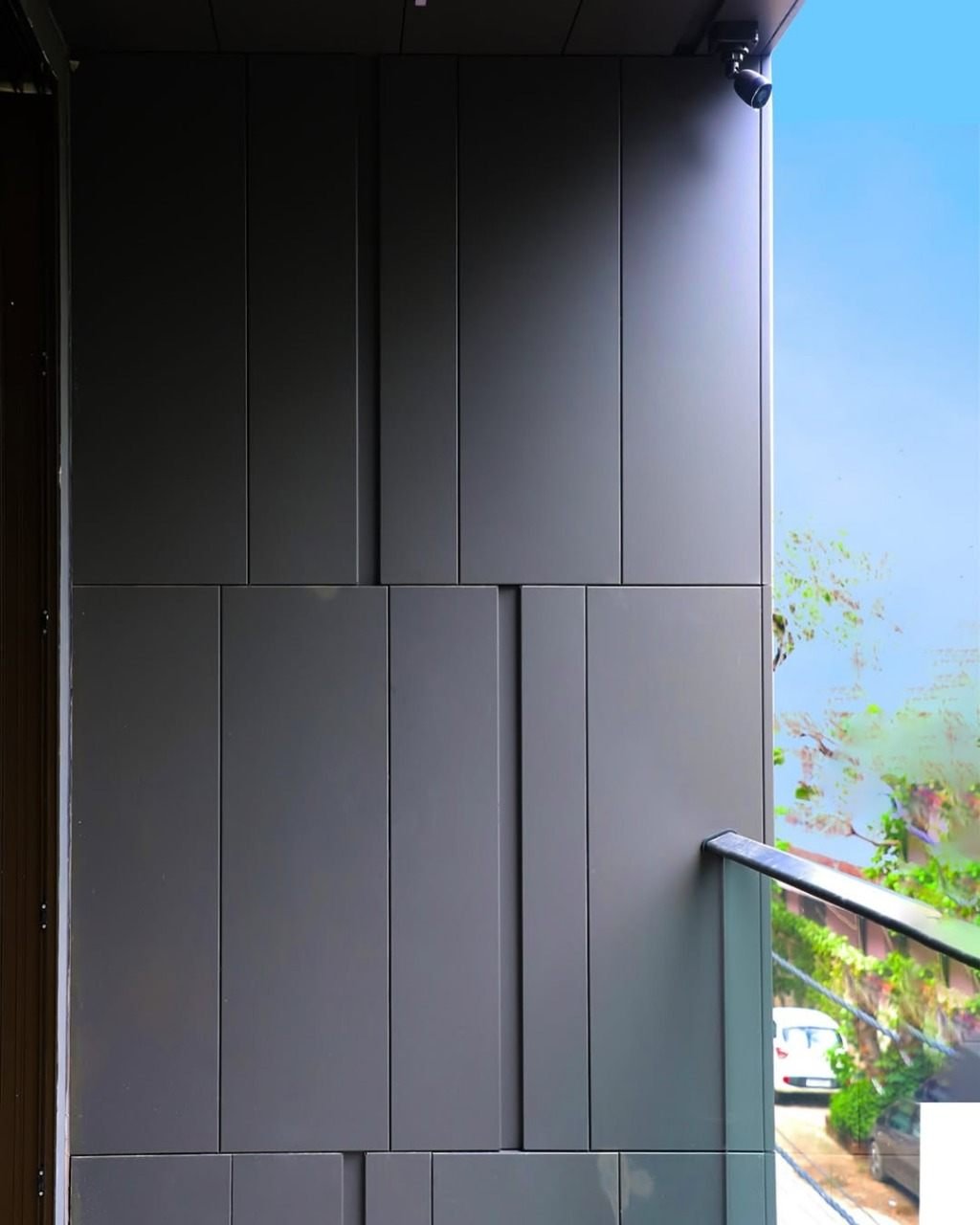 Matte charcoal ACP cladding with precise vertical panel joints